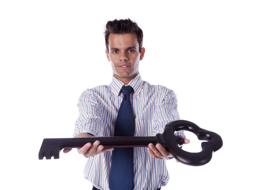 Businessman holding the big key to solve all the problems (isolated on white)